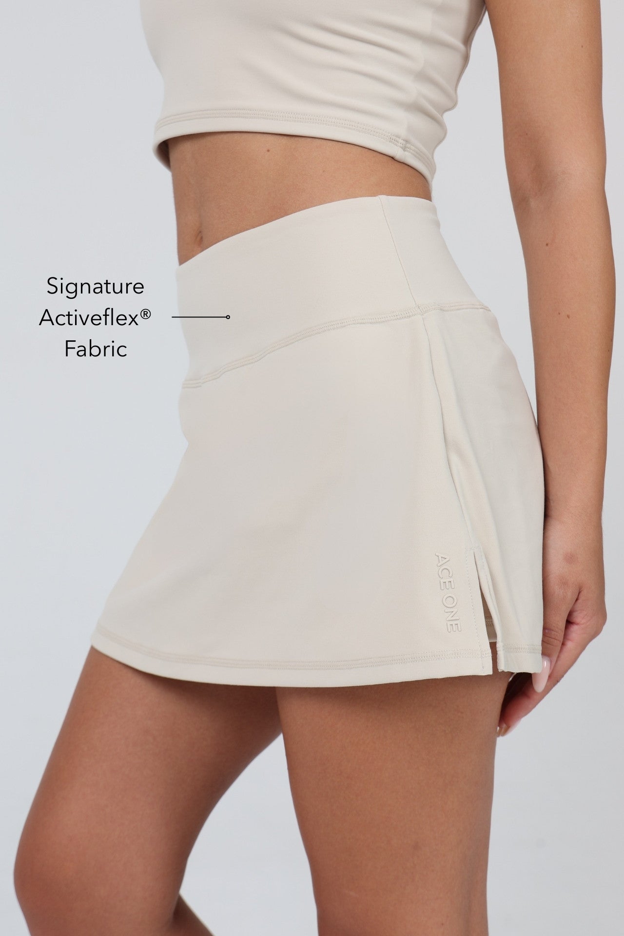 Woman wearing ACE ONE beige padel skort on court