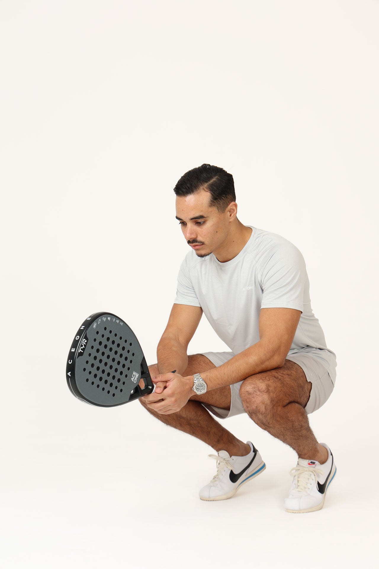 Player holding ACE ONE TŸR Grey Silver padel racket