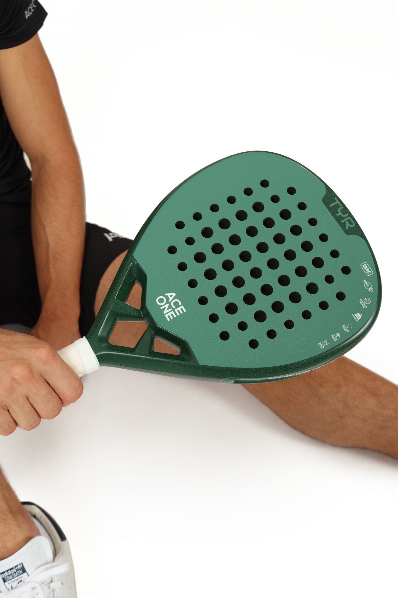 Player holding ACE ONE TŸR Green padel racket on court