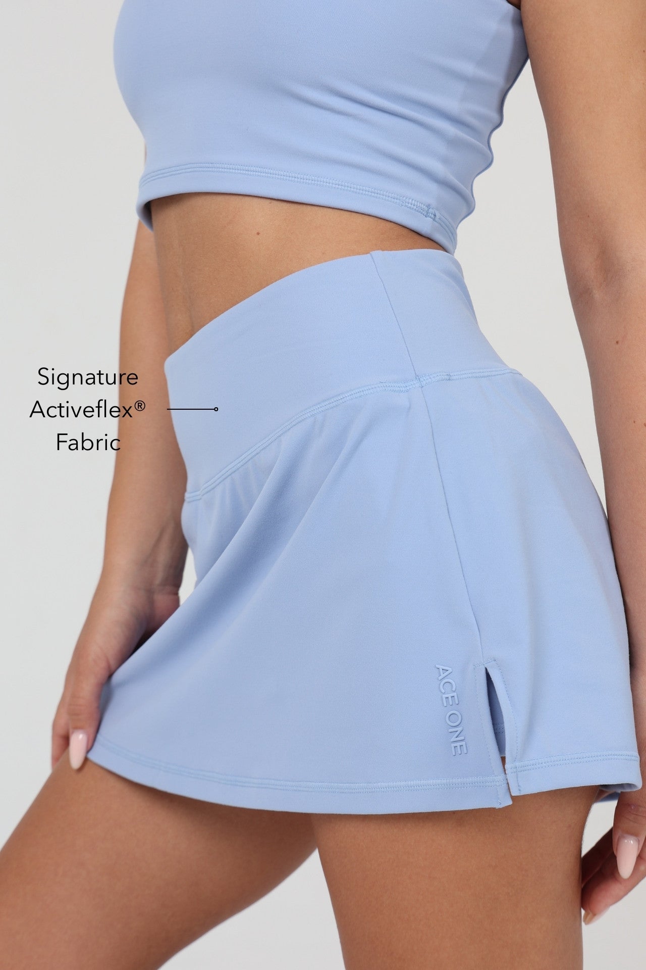 Woman wearing ACE ONE blue padel skort on court