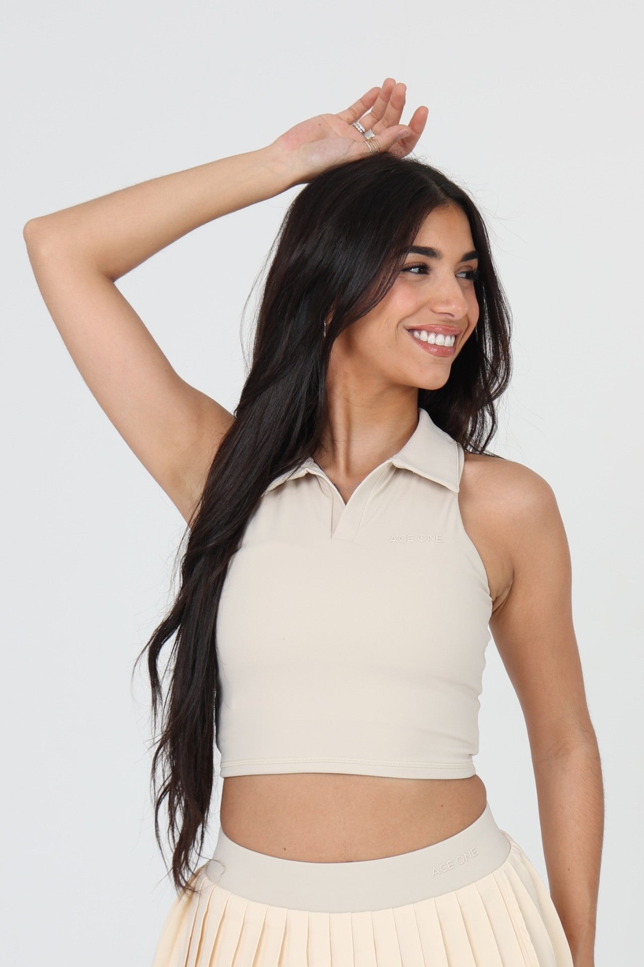 Woman wearing ACE ONE beige padel tank top on court